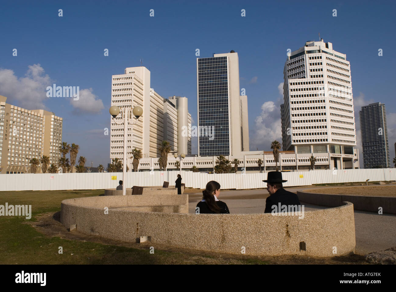 Young ultra orthodox Jewish couple sitting at Tel Aviv promenade along the Mediterranean seashore in Israel Stock Photo