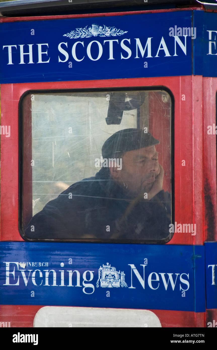 'The Scotsman' newspaper seller in his cabin on Princes Street, Edinburgh Stock Photo