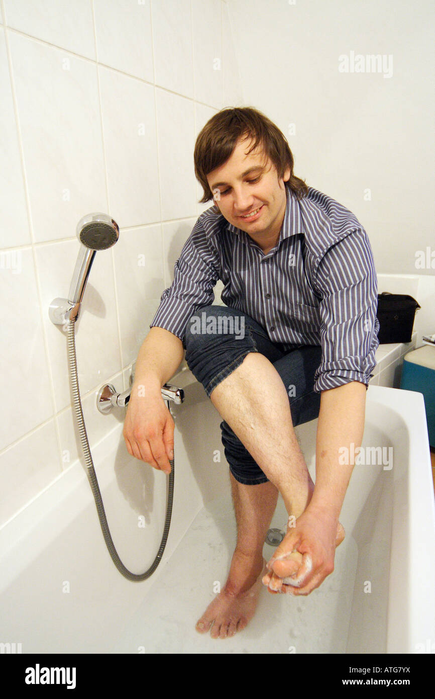 Young man washing his feet Stock Photo Alamy