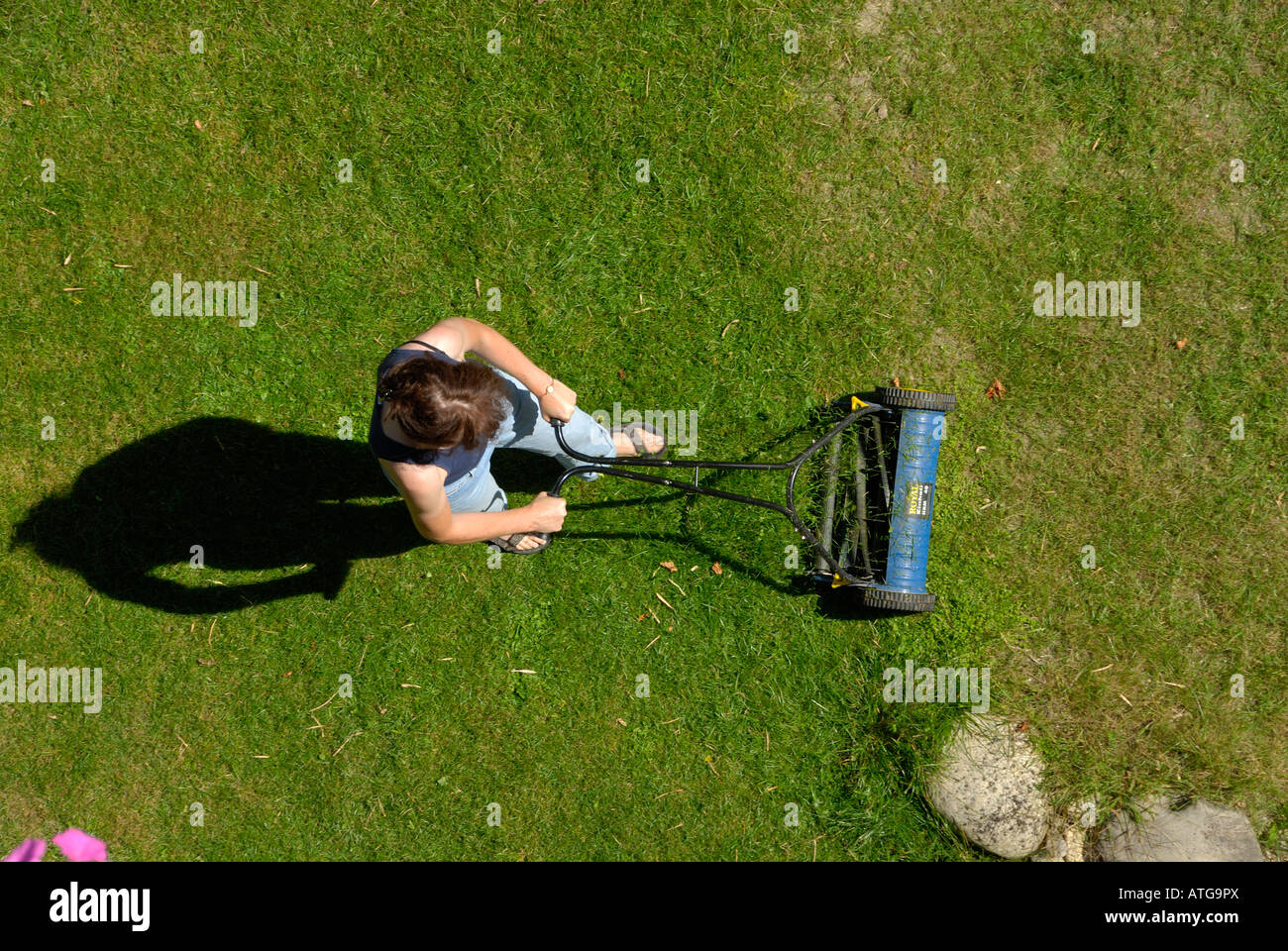 A Woman Mowing The Lawn With Shadow Birds Eye View Stock Photo