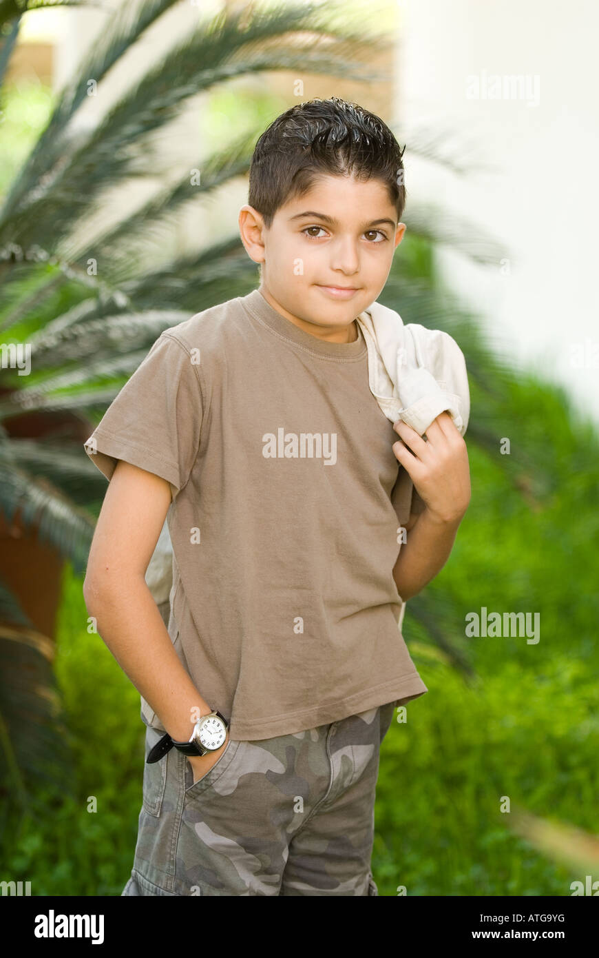 Young boy holding jacket outdoors Stock Photo