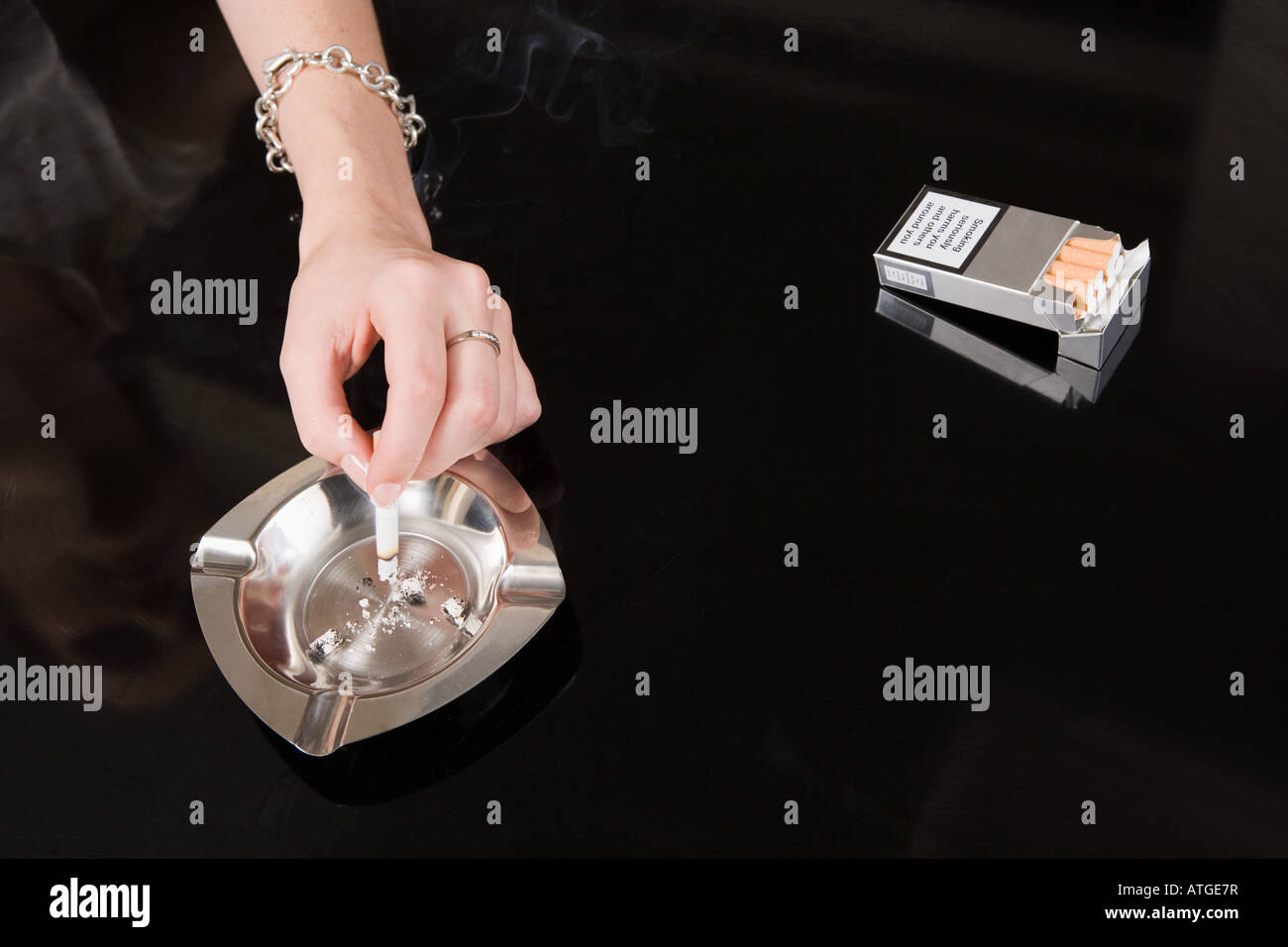 Woman stubbing out a cigarette Stock Photo