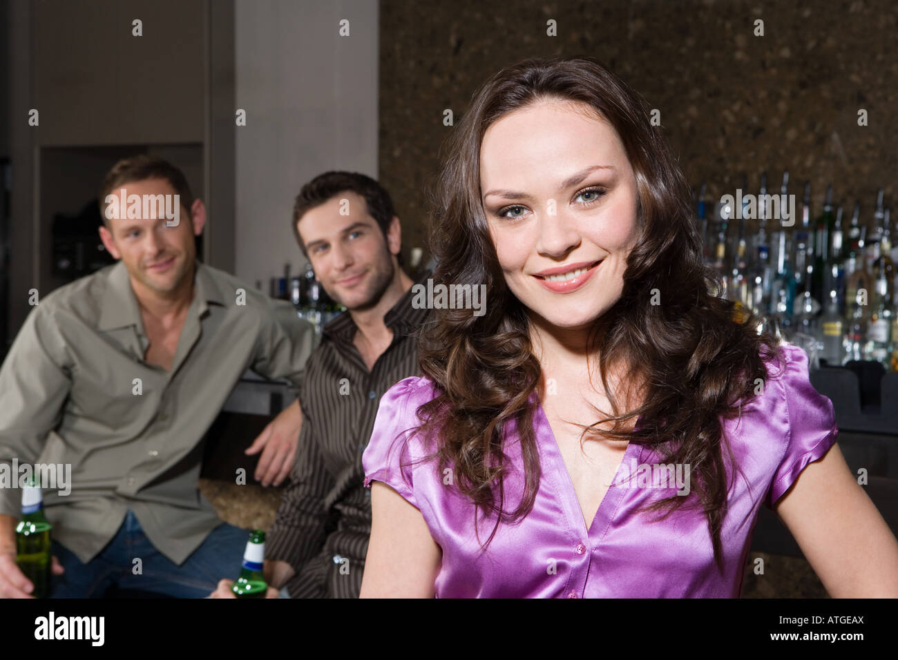 Men looking at a woman in bar Stock Photo
