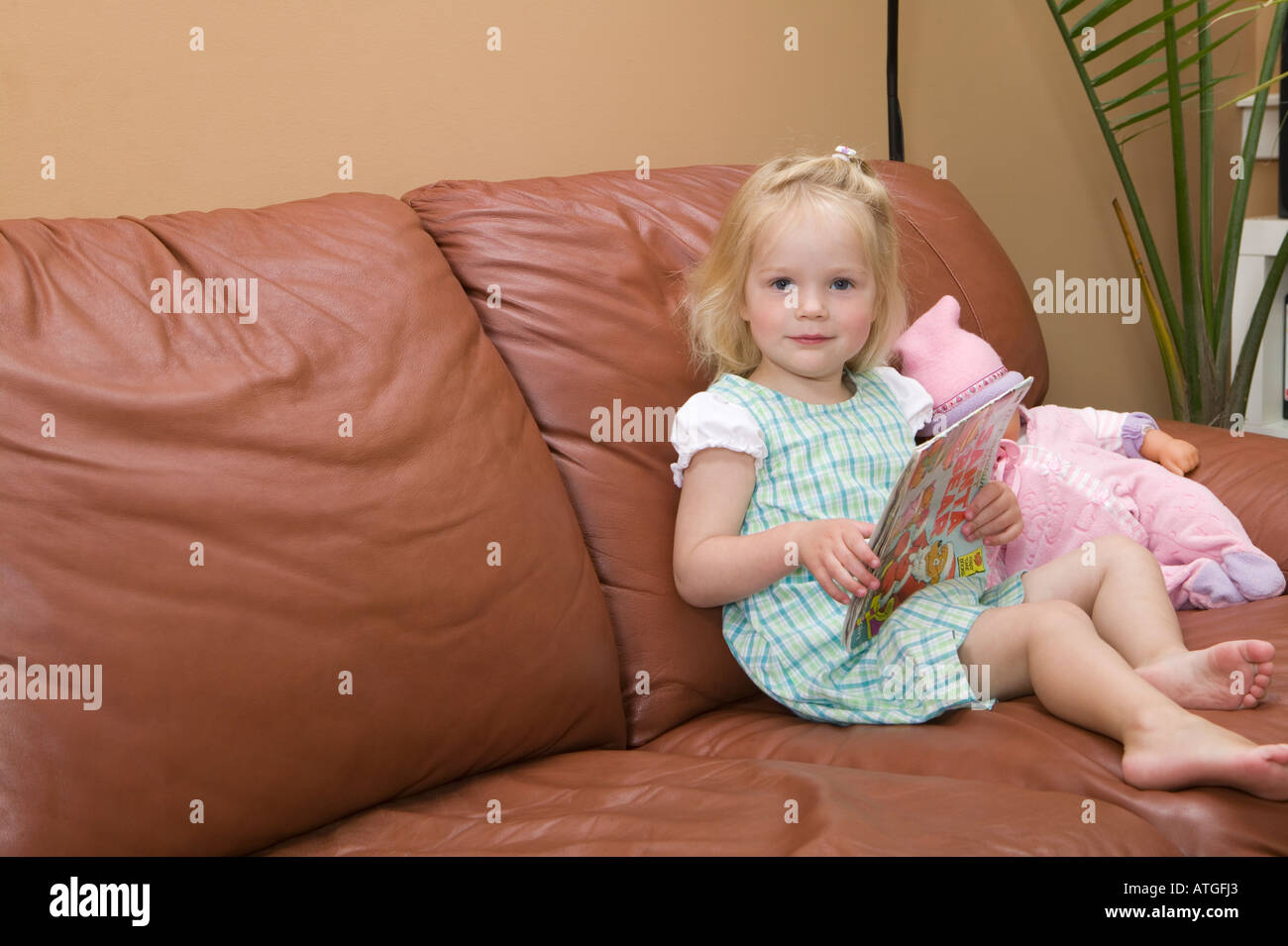 Young Girl Sitting on a Sofa Stock Photo