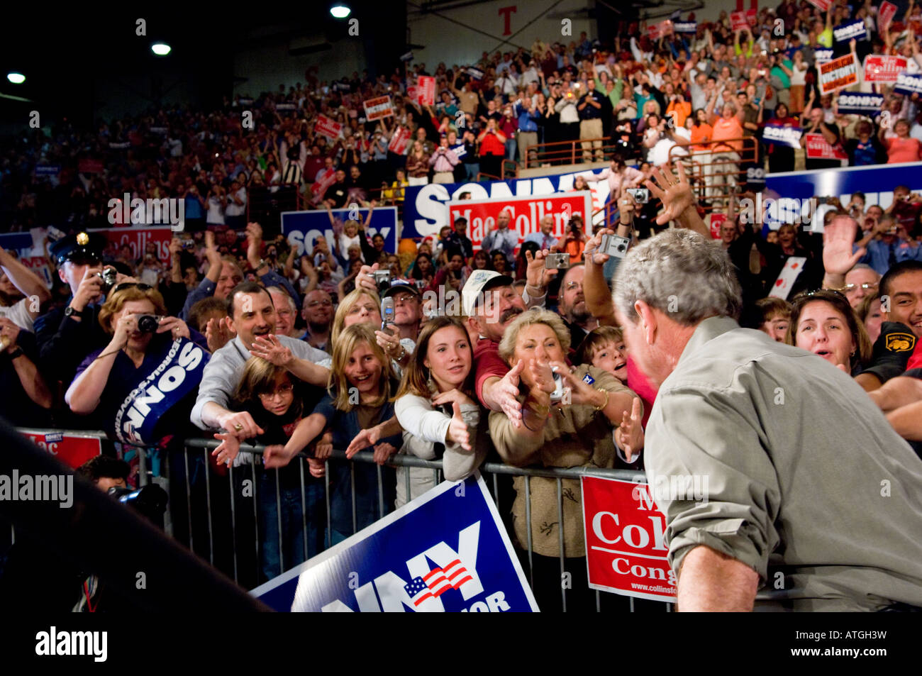 People in the crowd at a rally for Republican candidates reach out to shake hands with US President George W Bush Stock Photo