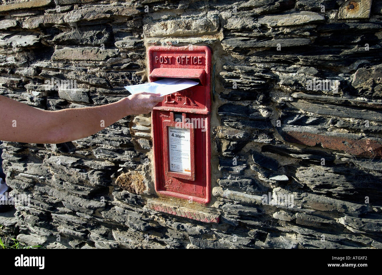 Postbox built into an old slate wall in the seaside fishing village of Port Gaverne near Port Isaac North Cornwall Stock Photo