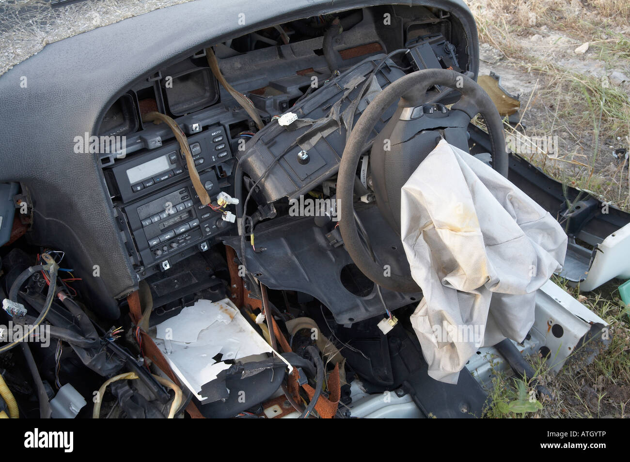 smashed up dash section of a car in a wrecking yard showing the