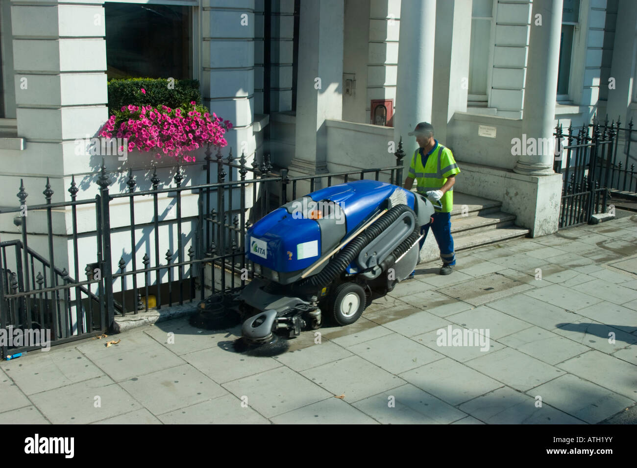 Street sweeper and sweeping machine on the streets of London Stock