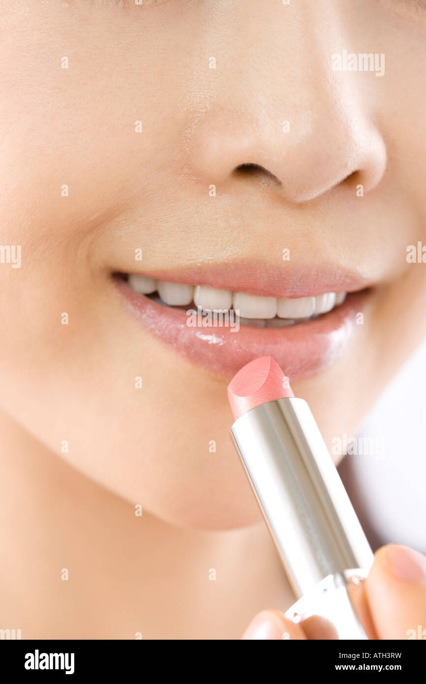 Young woman applying lipstick Stock Photo