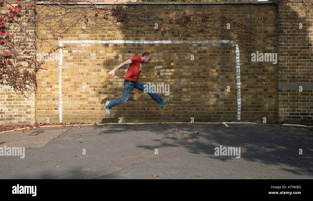 Football fan jumping across a goal Stock Photo Alamy