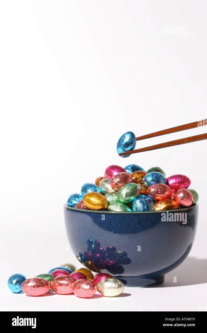 Noodle bowl filled with mini chocolate Easter eggs with chop sticks