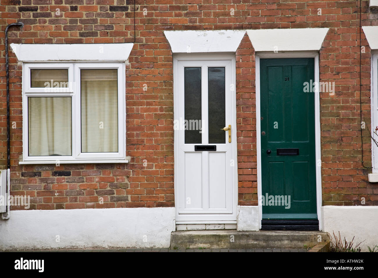 Victorian terraced houses one with uPVC replacement window showing lintels above the door and window, Haslemere, Surrey, England Stock Photo