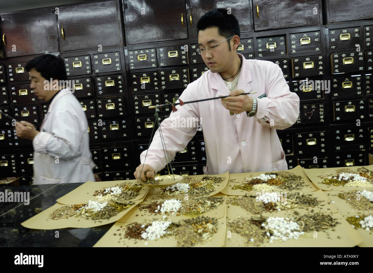 Chinese herbalist weighing herbal medicine using traditional scale in