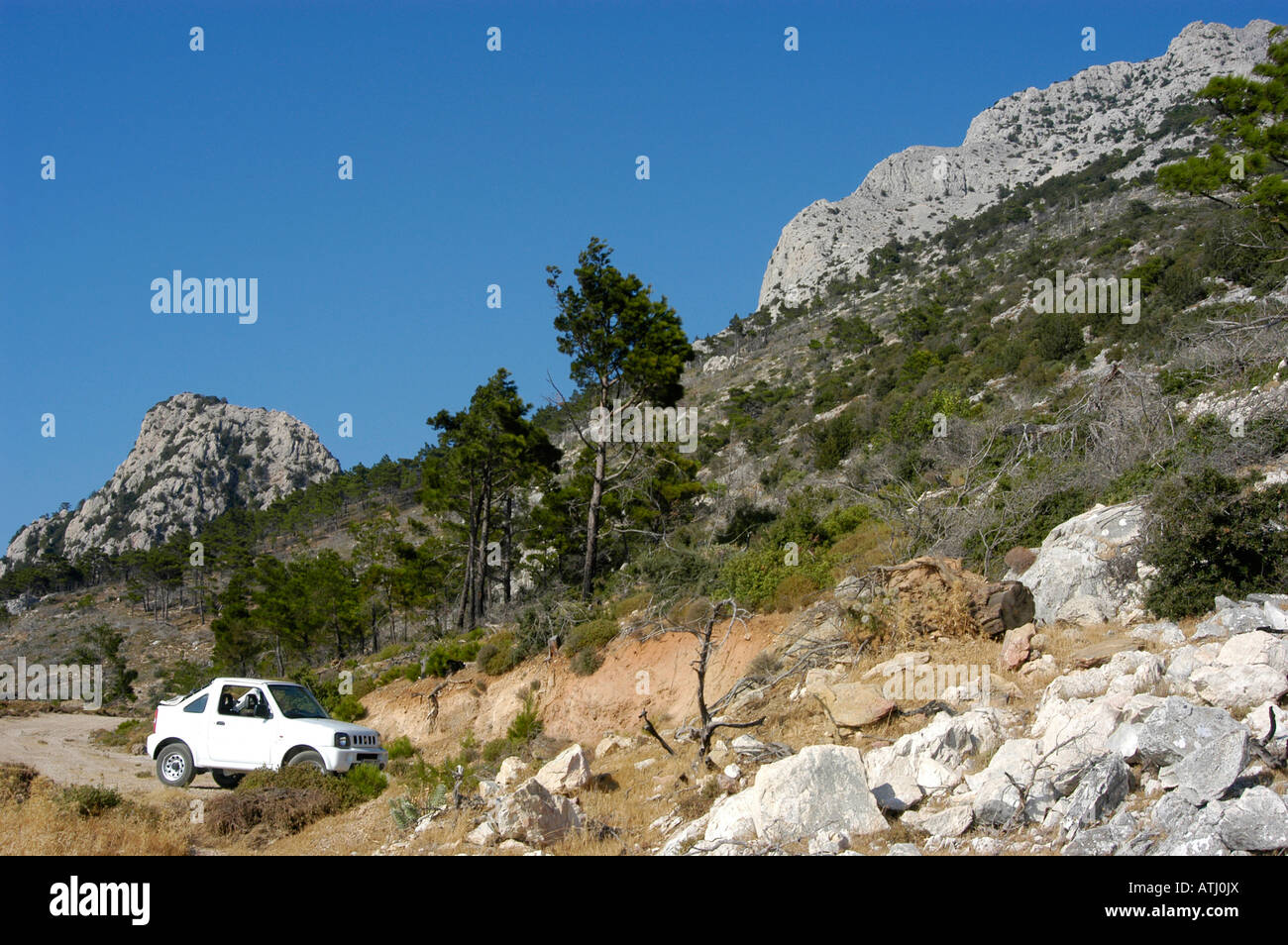 White jeep in rough terrain of mountain area. Stock Photo