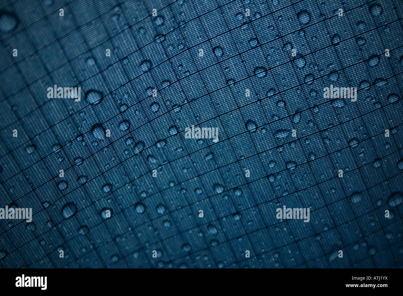 photo showing rain drops on the outside of tent canvas with stitching patterns Stock Photo