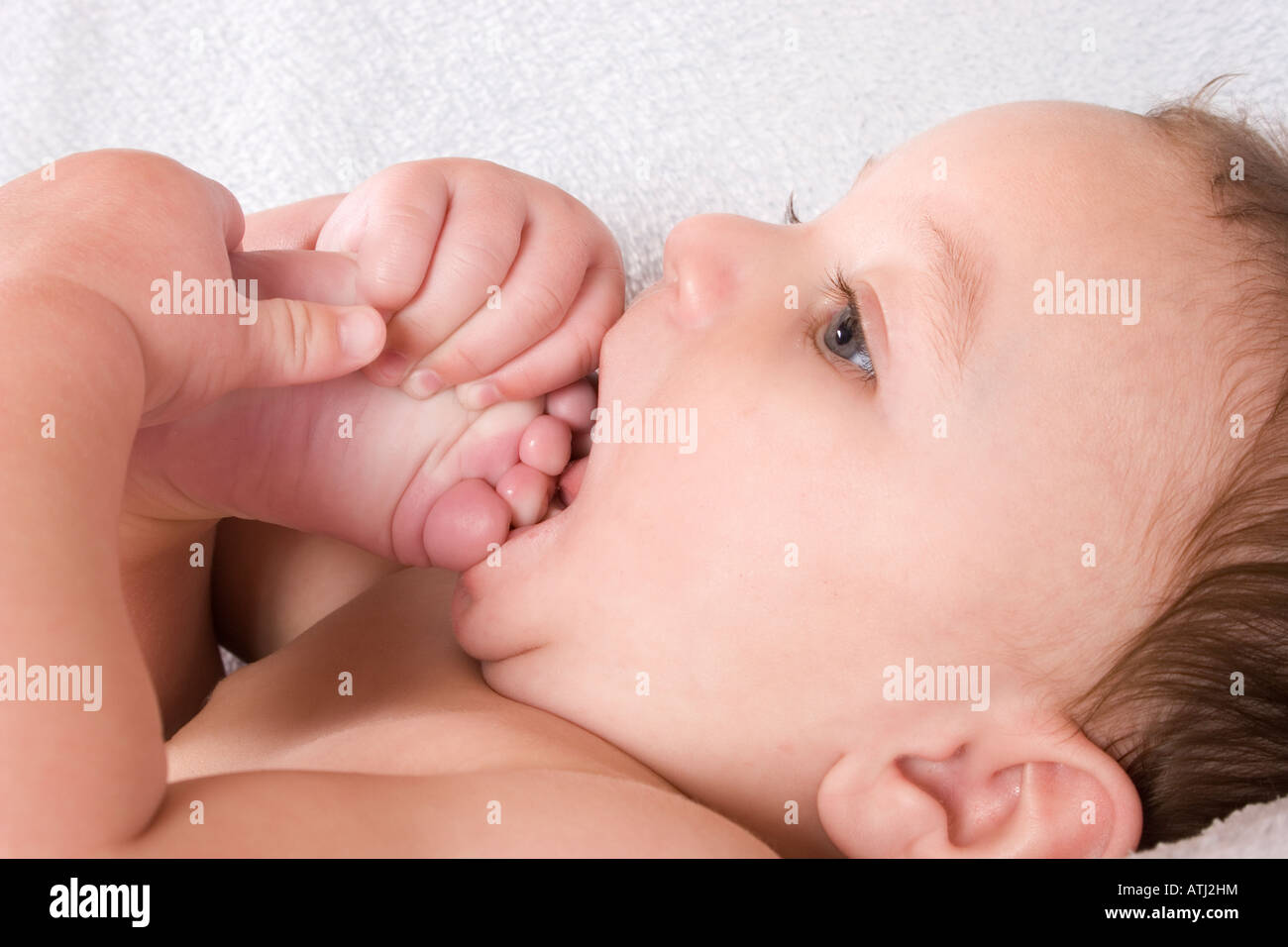 6 month old baby putting toes in mouth Stock Photo