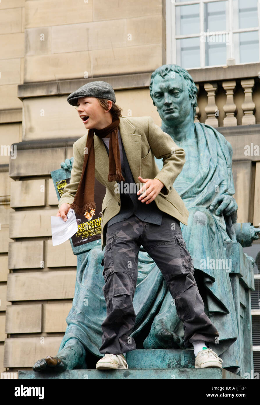 Edinburgh Festival Fringe, Scotland. Street performer promotes evening shows from Victorian statue in the High Street Stock Photo