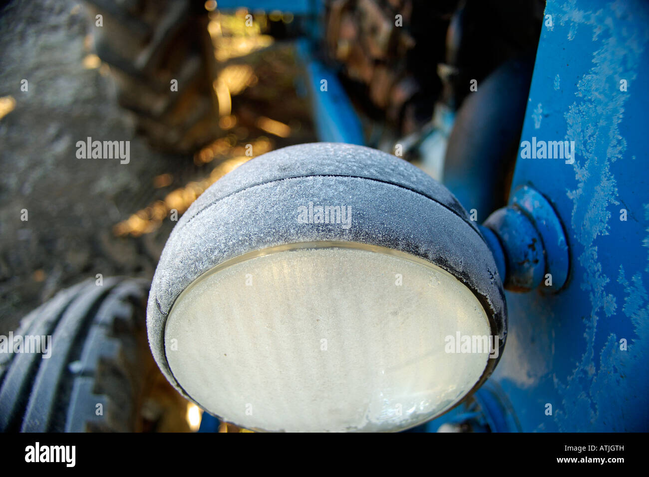 Frost on the beacon of a blue tractor during a cold morning of winter Stock Photo