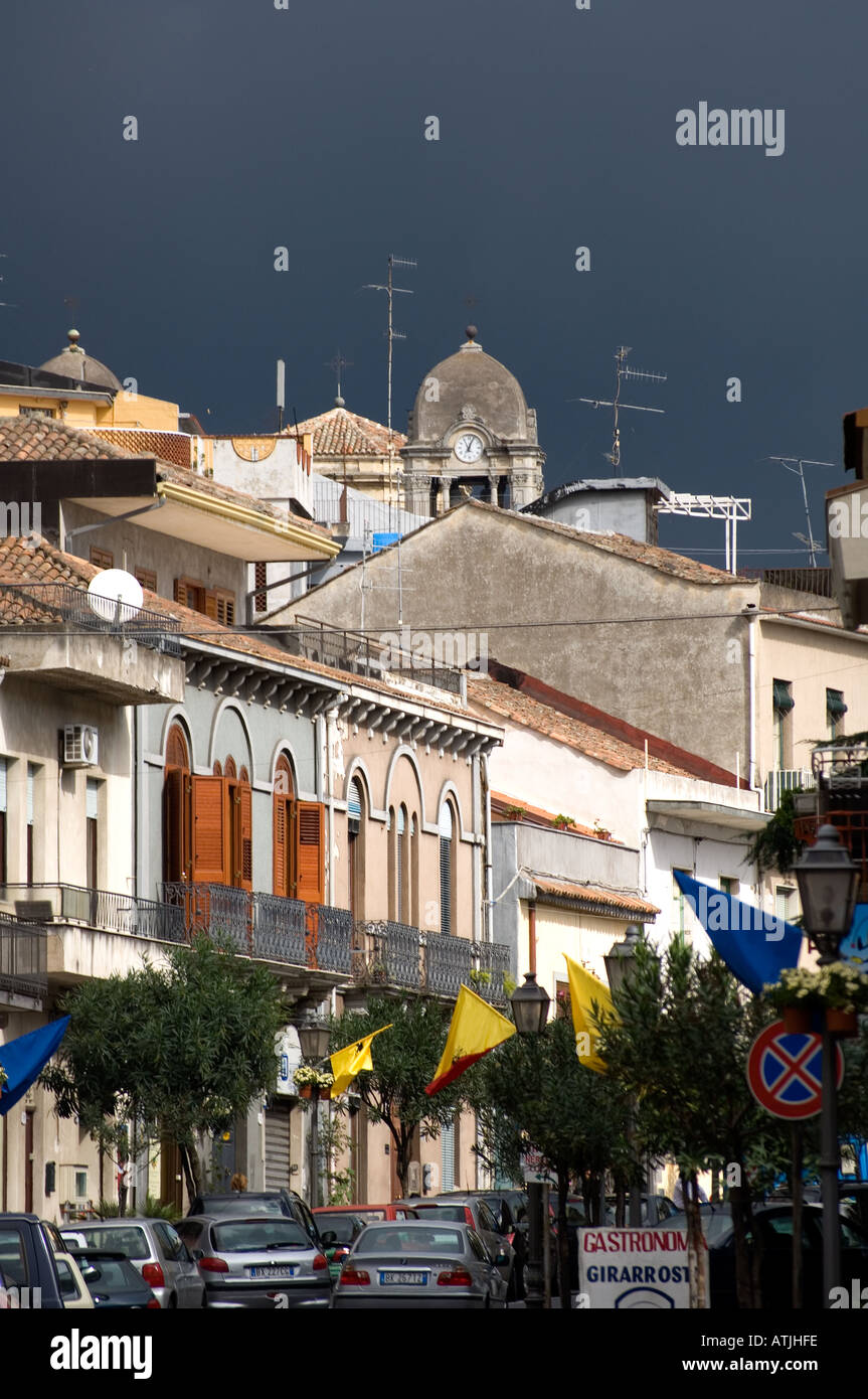 A view of the buildings of the village of Zafferana Etnea on the slopes of Mount Etna against a threatening sky. Stock Photo
