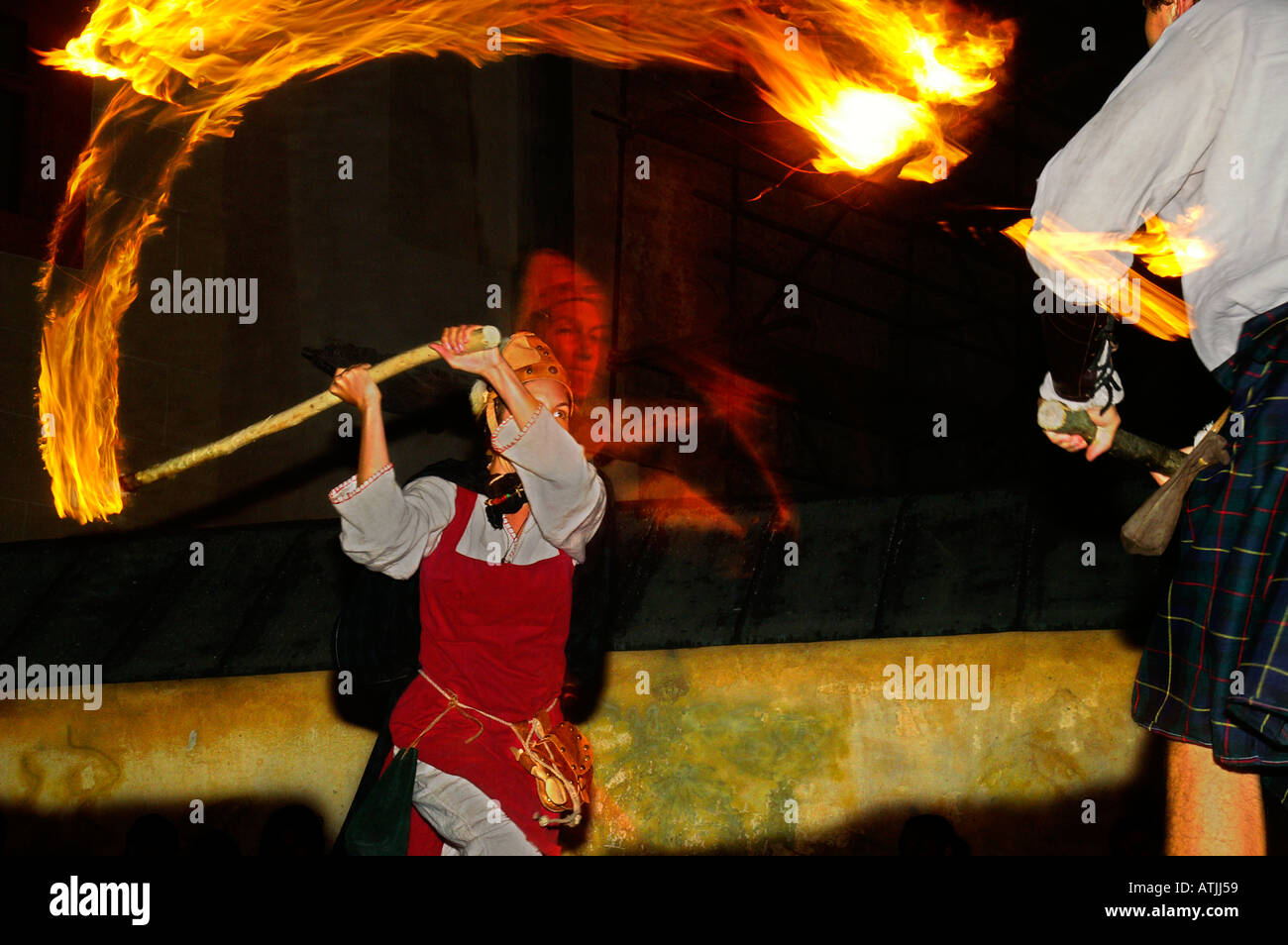 Clashes with blazing facules, fighting with flames, night medieval wrestling performance Stock Photo