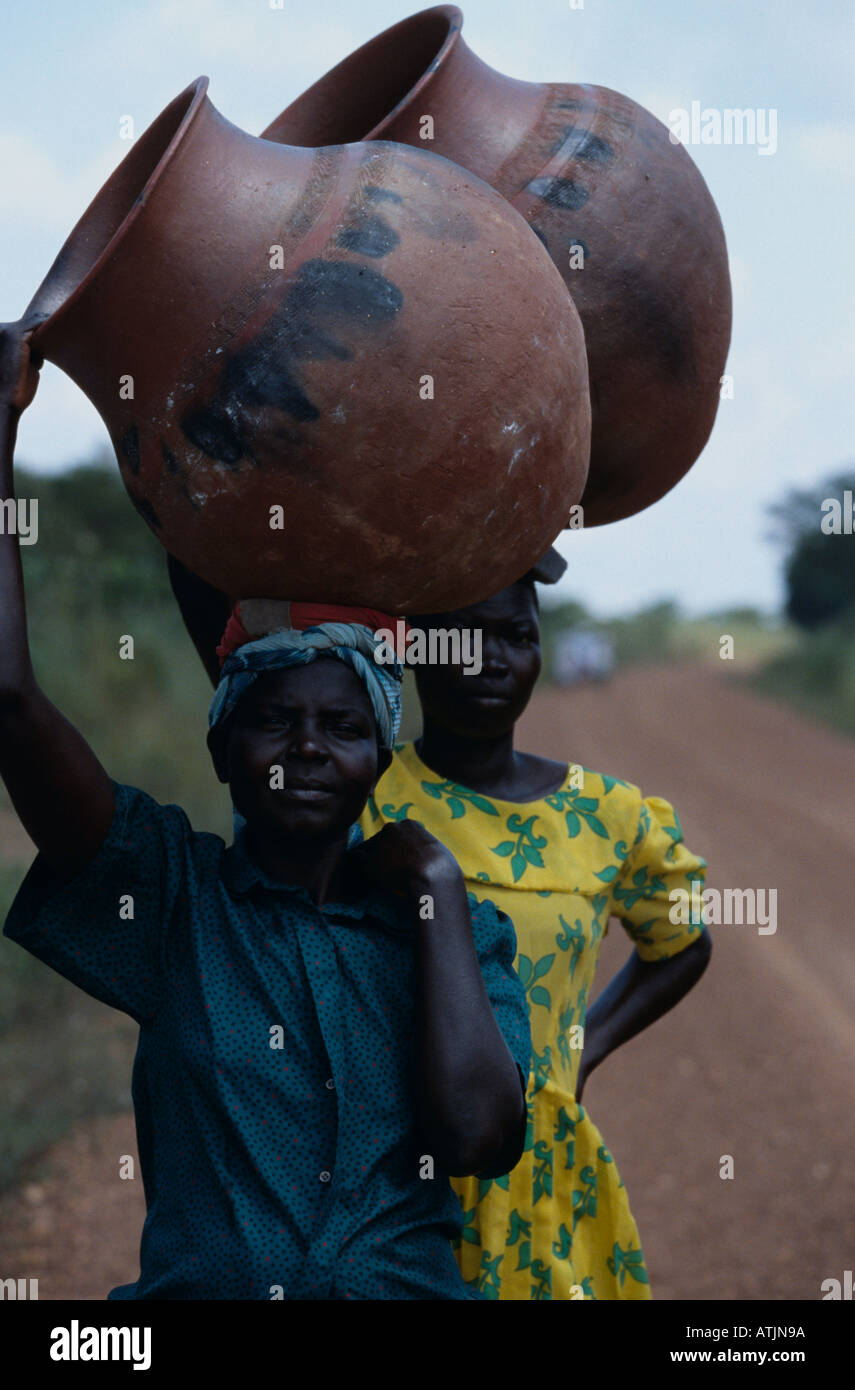 Karamoja women carrying earthen jars on their head. Uganda. Stock Photo