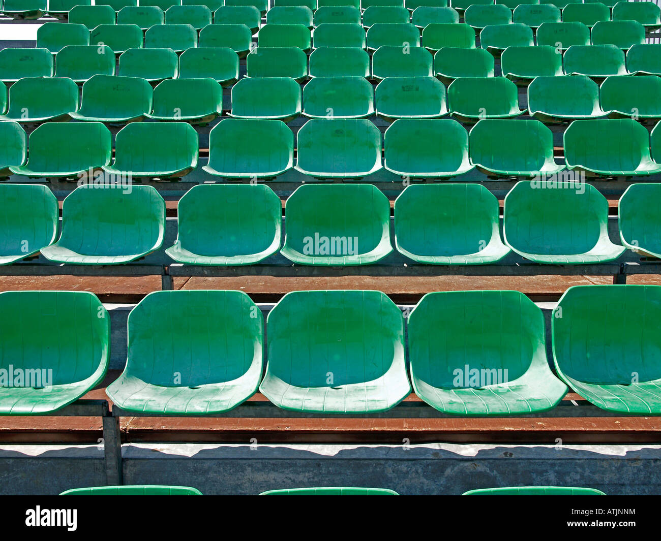 sports field with empty grandstand with rows of seats for viewers Stock