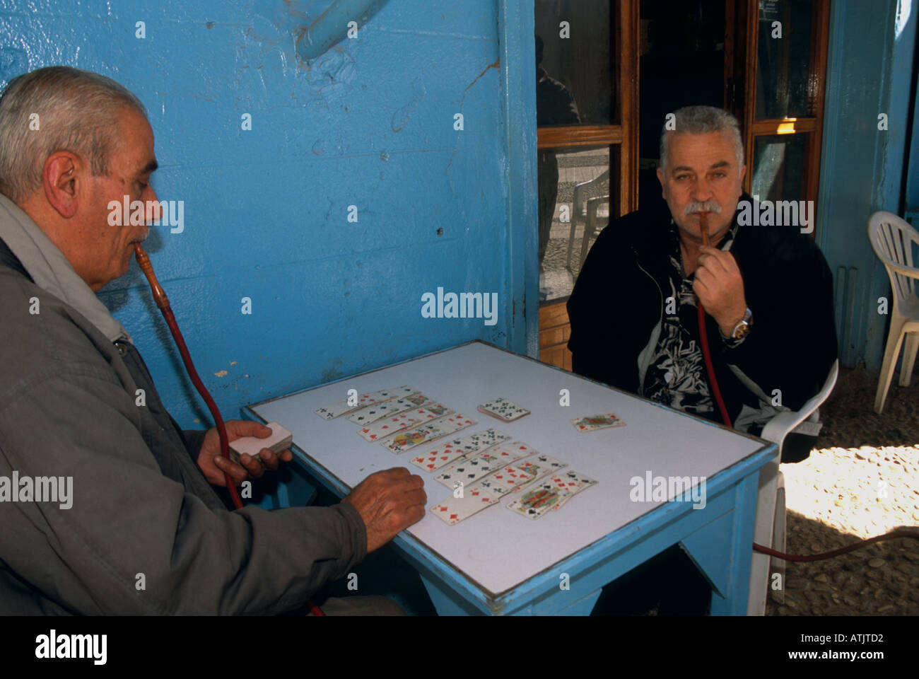 Elderly men smoking hookah and playing card game, Saida, Lebanon Stock Photo