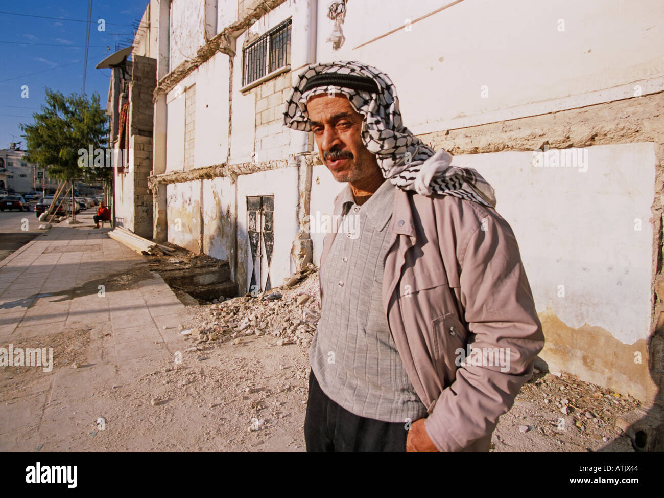 Local man beside partly damaged building, Amman, Jordan Stock Photo