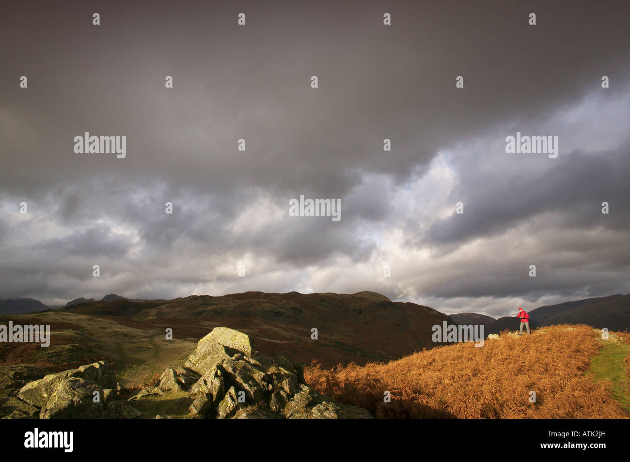 Hiker in Lake District fells with storm clouds Stock Photo - Alamy