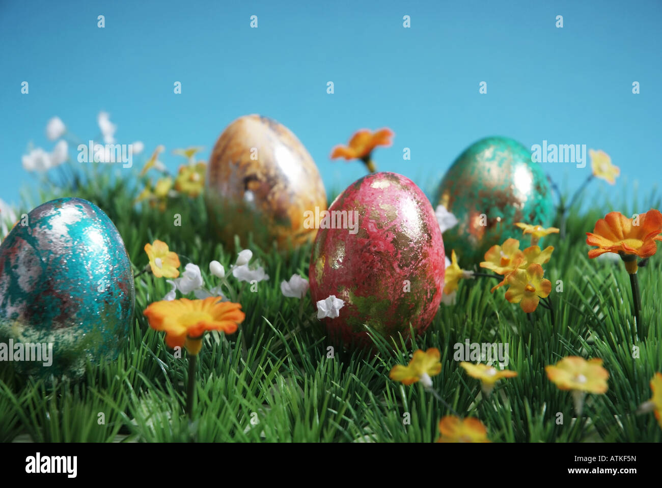colorful easter eggs on grass blue background Bunte Ostereier auf Gras vor himmelblauem Hintergrund Stock Photo