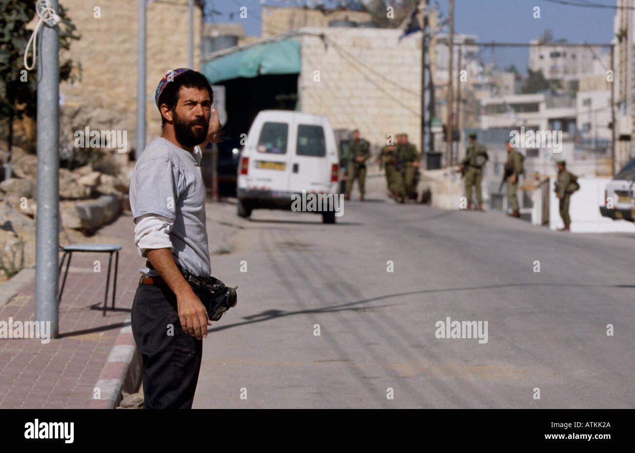 Jewish settler looking away from soldiers, Hebron, West Bank, Jerusalem Stock Photo