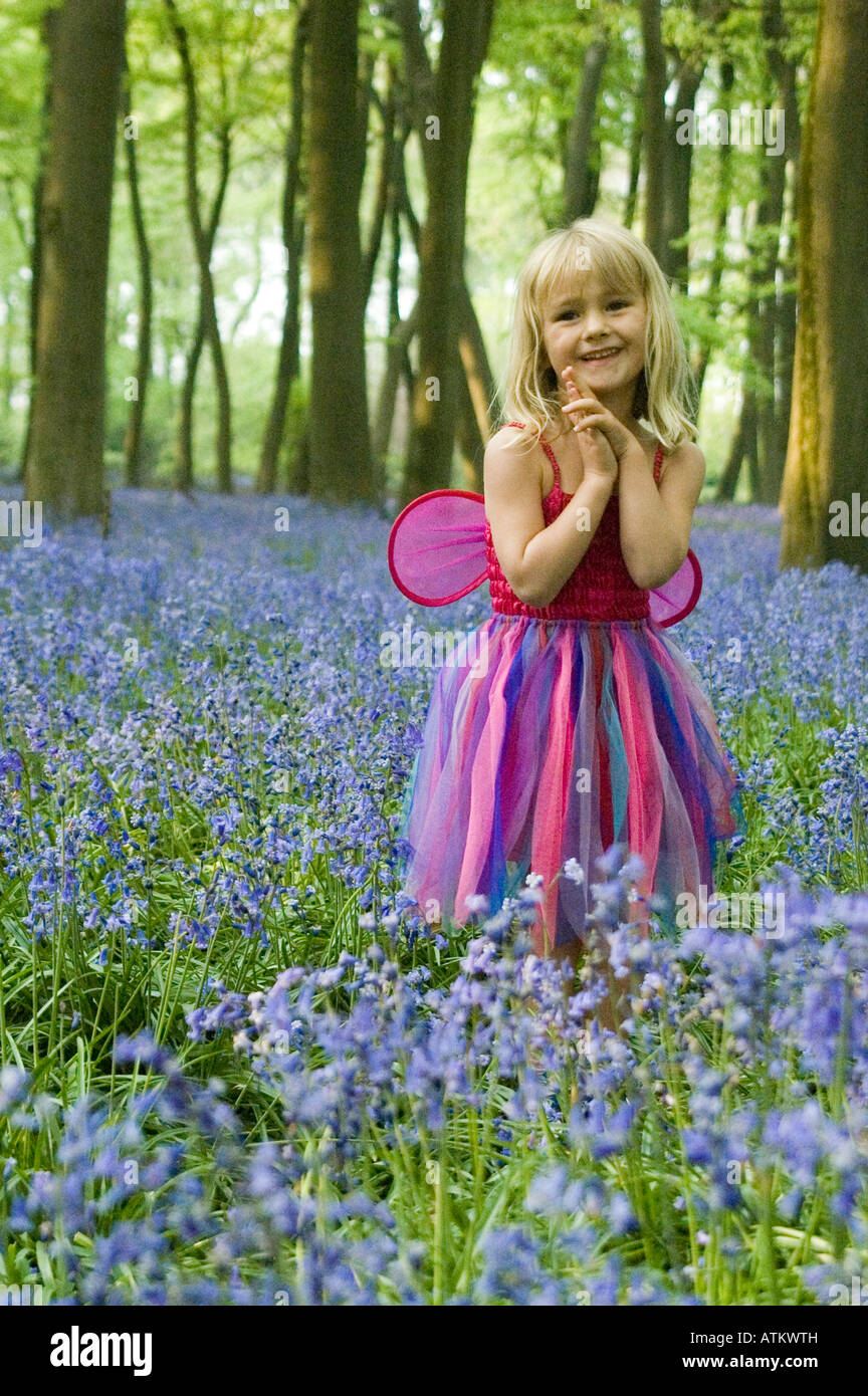A five year old girl dressed in a fairy outfit in an English bluebell