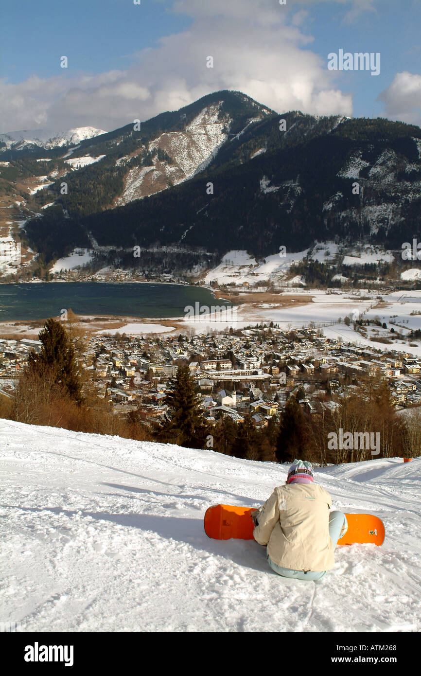 Snowboarder skier on the slopes of the Schmittenhohe mountain overlooking Schuttdorf and Lake Zell am See  Stock Photo