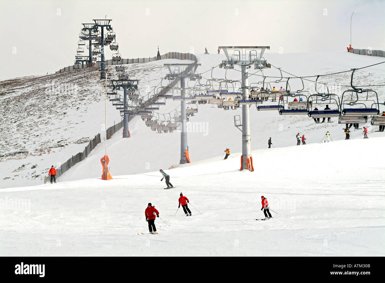 Skiers snowboarders and chair lift on the slopes of Schmittenhohe mountain above Zell am See Stock Photo