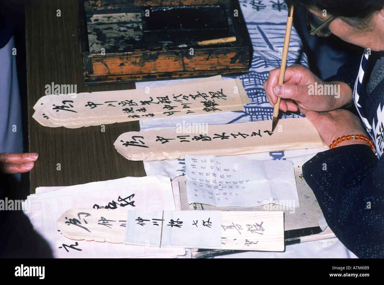 Writing prayers on toba sticks outside Buddhist temple in Japan Stock Photo