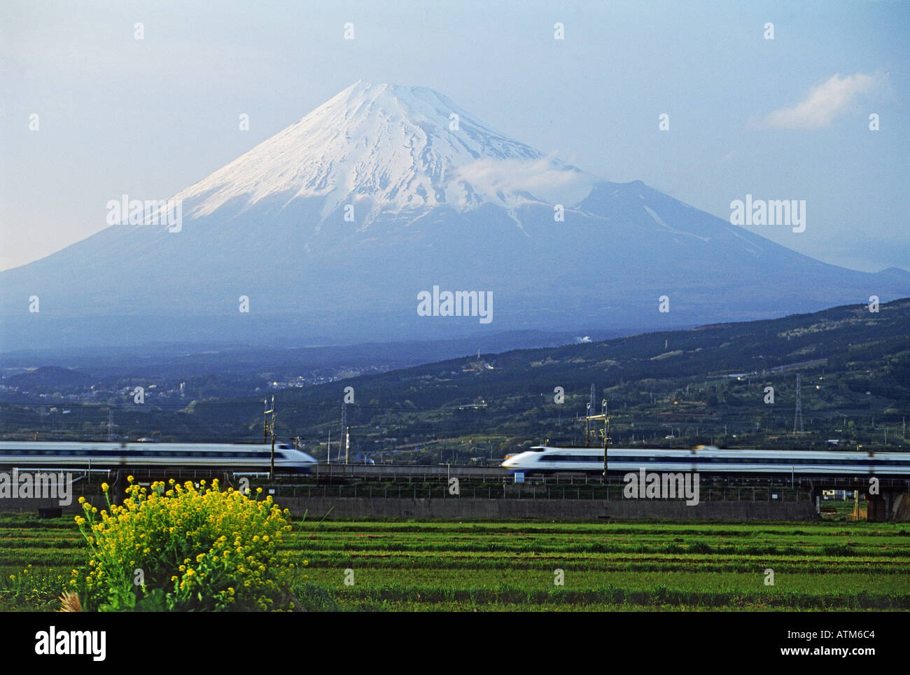 Two Shinkansen bullet trains passing below Mount Fuji Stock Photo