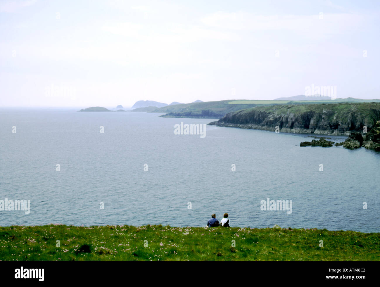 Couple sitting on cliff top hi-res stock photography and images - Alamy
