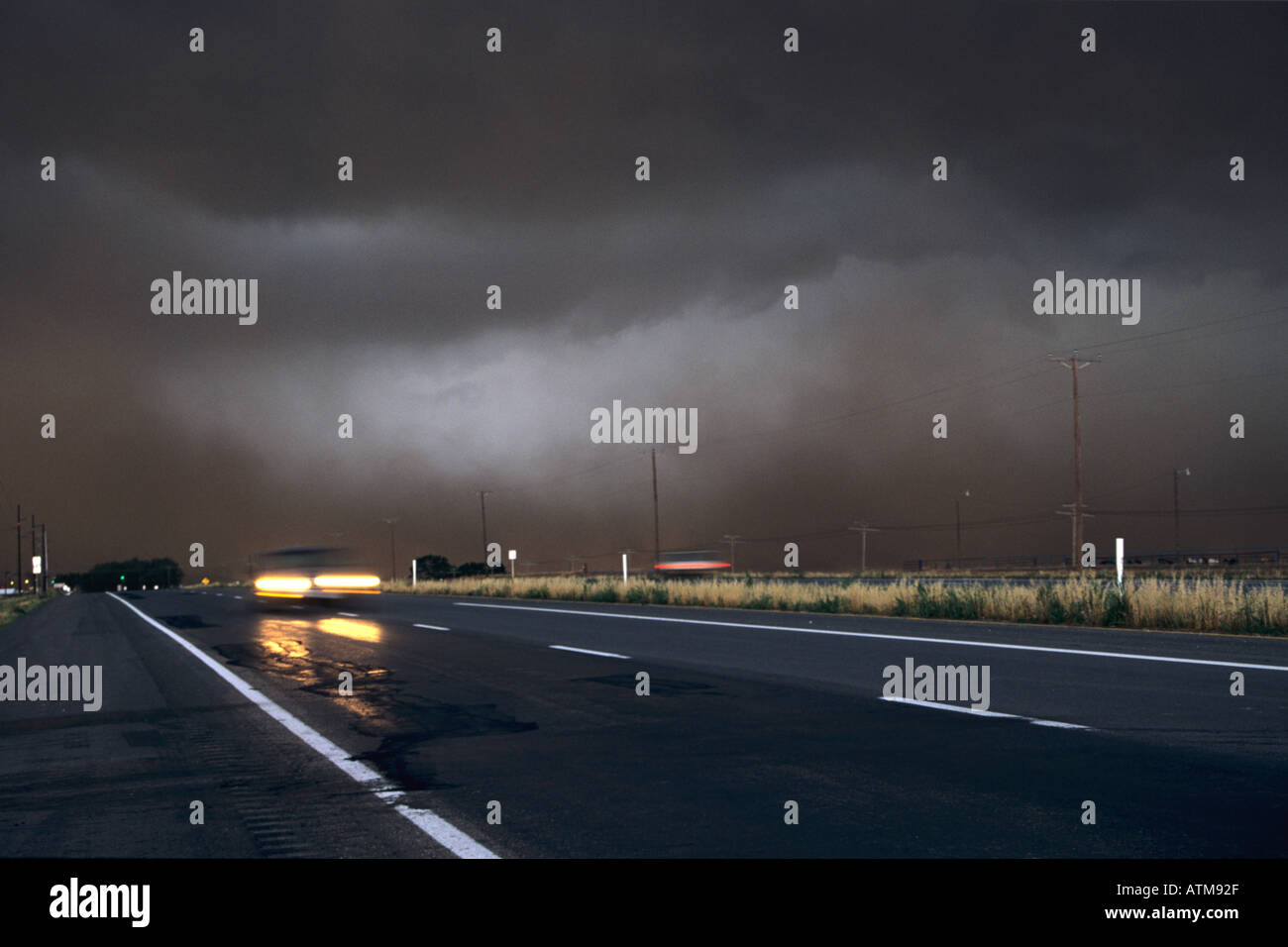 car flees along a road ahead of an advancing gust front from a severe storm Texas USA Stock Photo