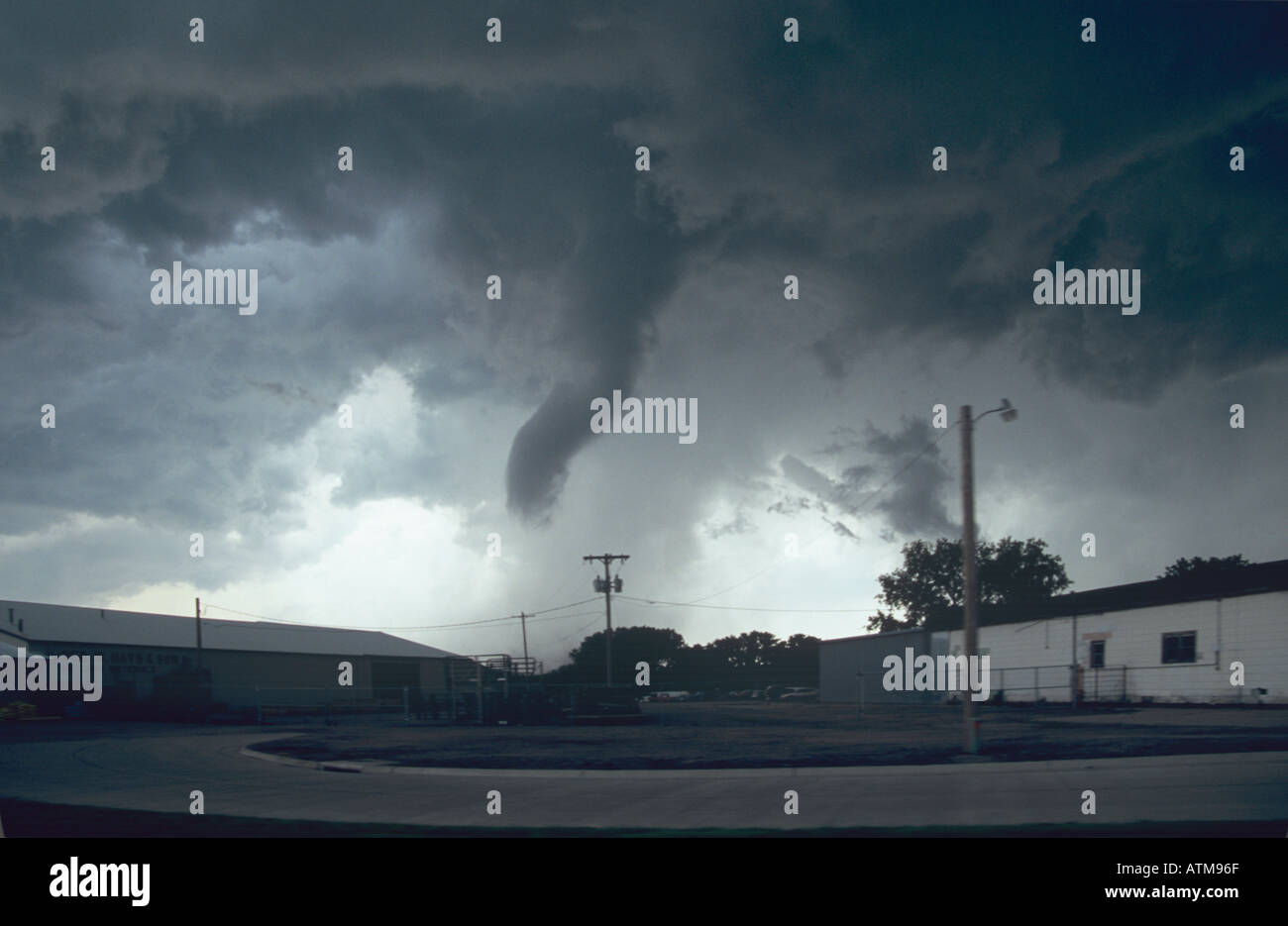A tornado touches down behind farm buildings in rural Nebraska, USA. May 2004 Stock Photo