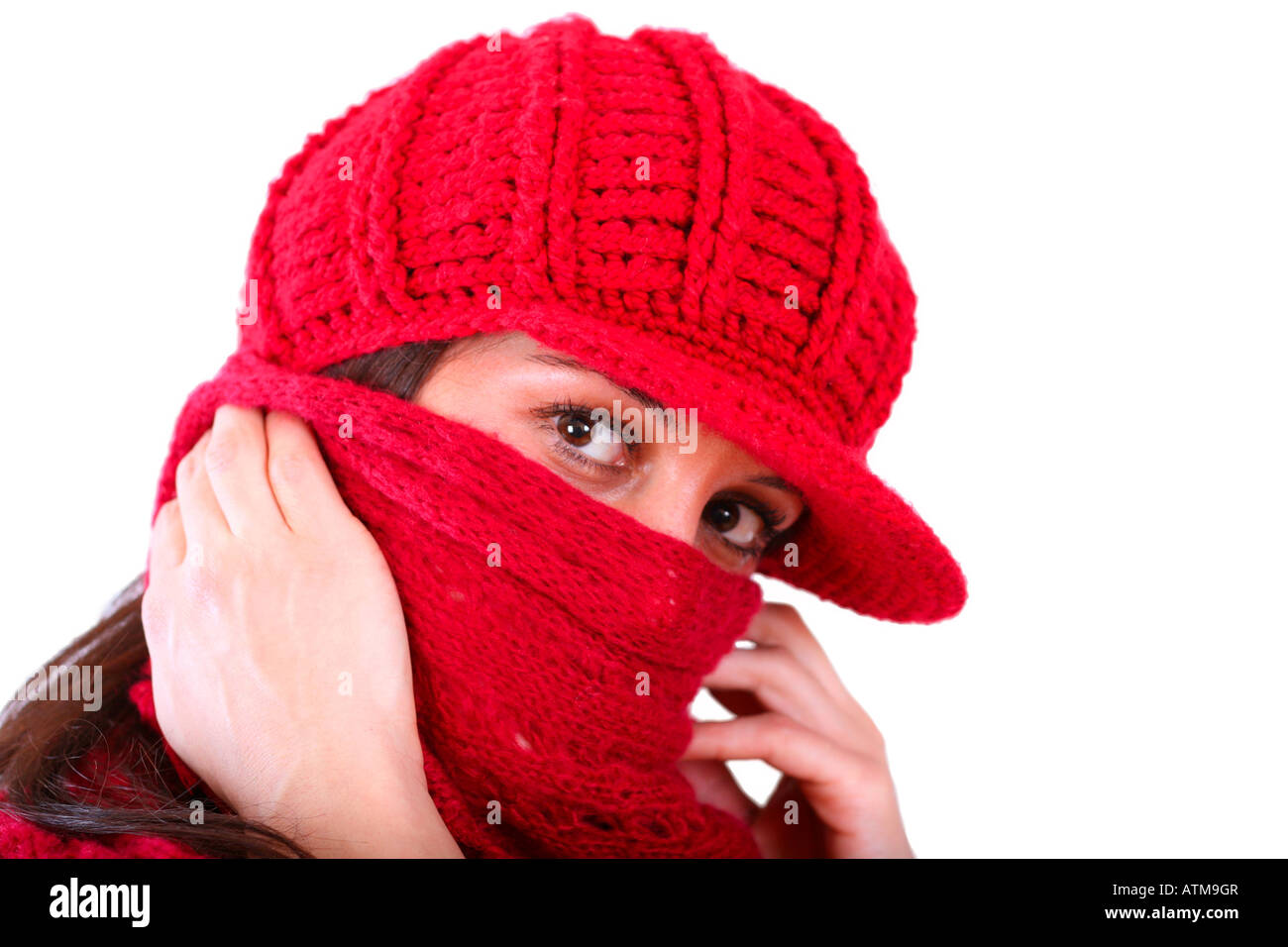 Brunette with a red hat and a red shawl hiding face (almost oriental or arabic look) Stock Photo