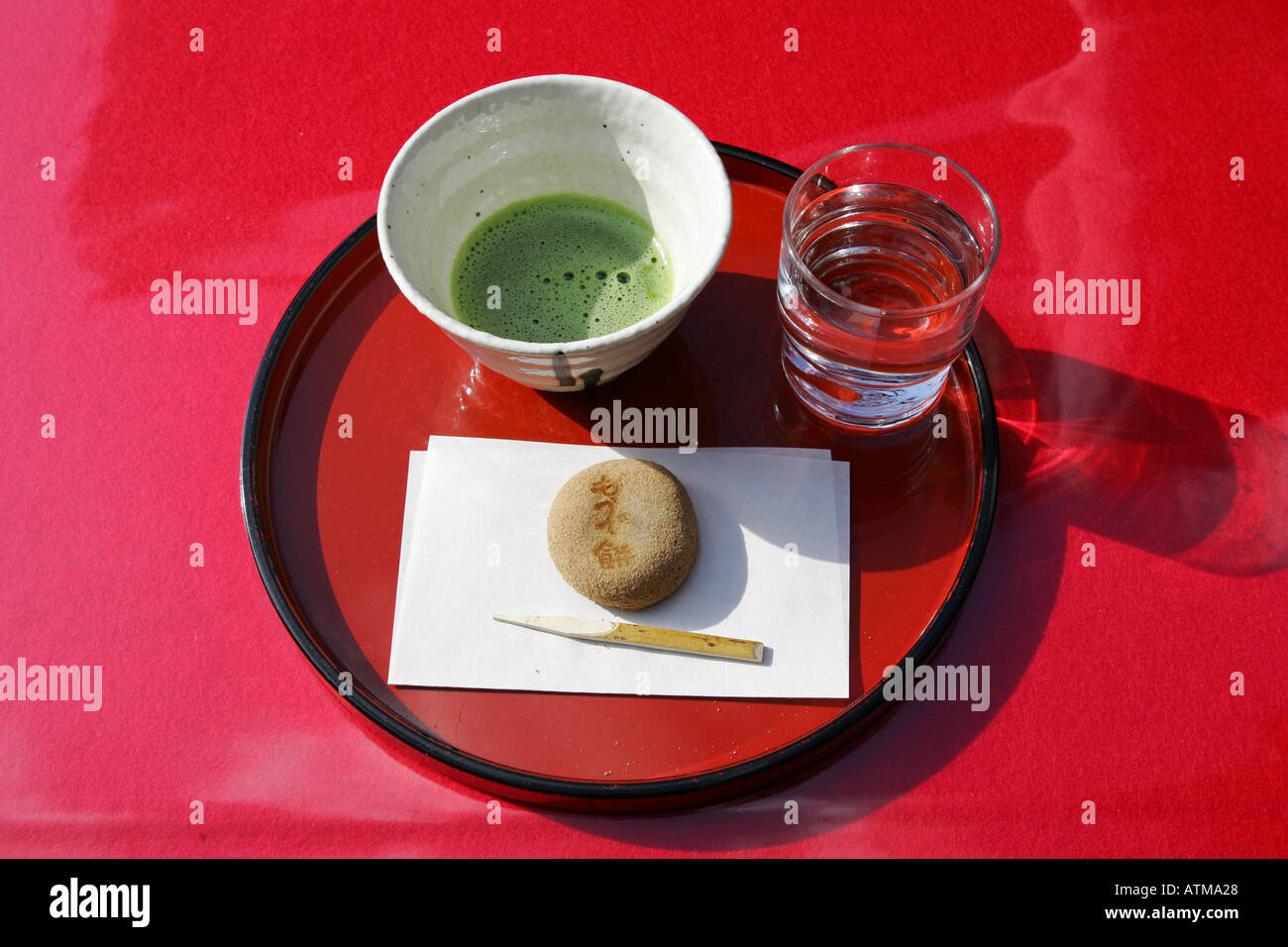 Traditional Japanese green tea is served with mochi rice sweet on a red lacquer tray Tokyo Japan Stock Photo