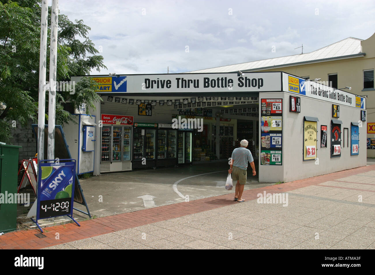 A man walks into a drive through off license alcohol beer bottle shop