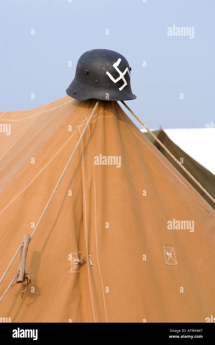 German helmet with Swastika painted on the front on tent pole Stock Photo