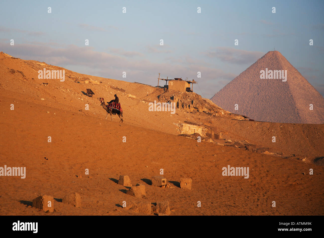 A camel rider works his way up the hill around the Pyramids, early in the morning. Stock Photo