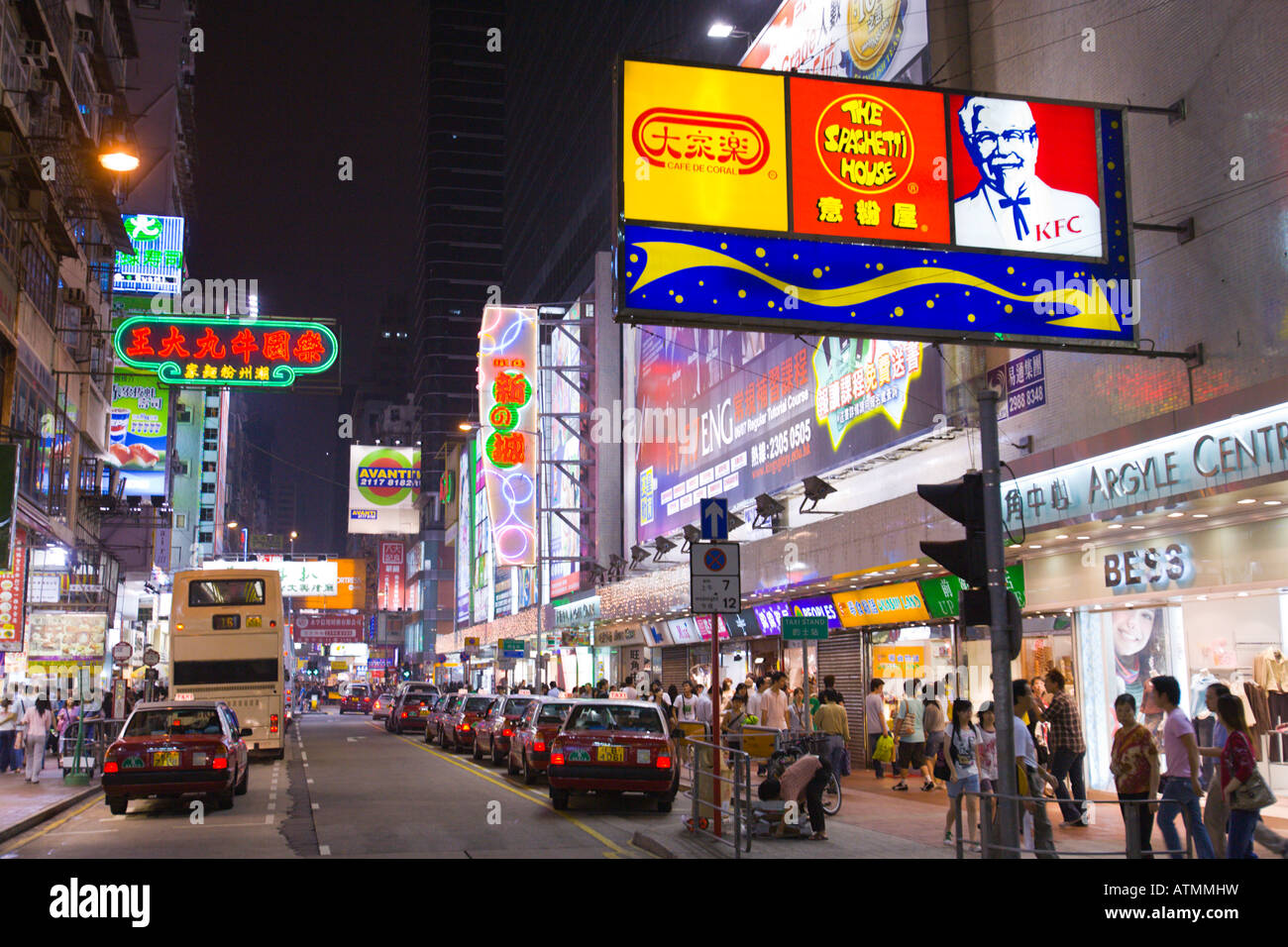 HONG KONG CHINA Colorful neon signs and traffic in busy Mong Kok neighborhood at night in Kowloon Stock Photo