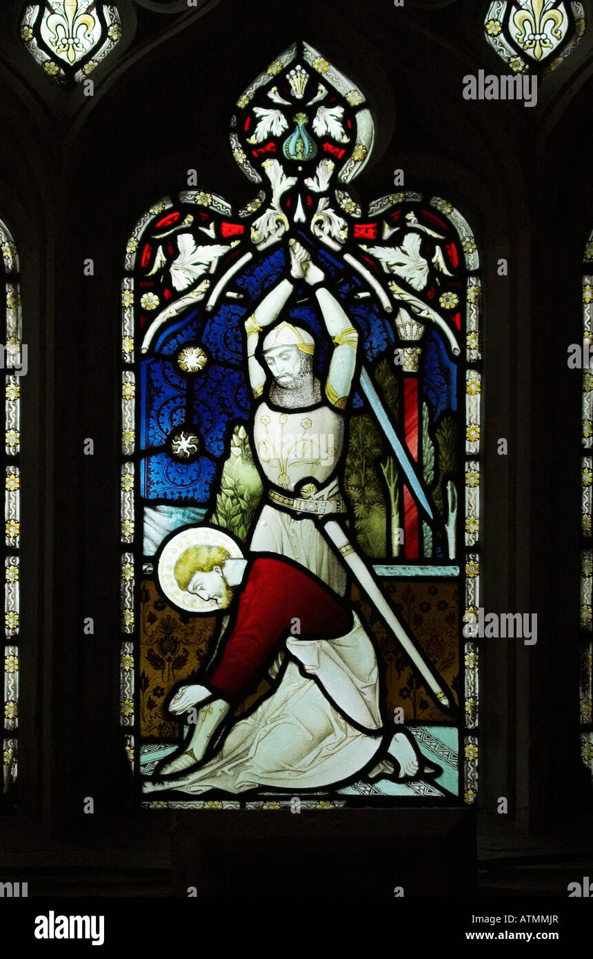 Knight about to behead a praying victim with a sword. Stained glass window Gloucester cathedral England Stock Photo