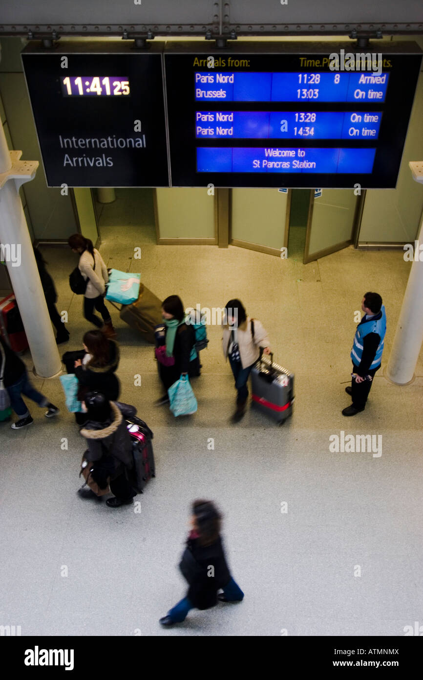 commuters leaving eurostar platform under international arrivals indicator board Stock Photo