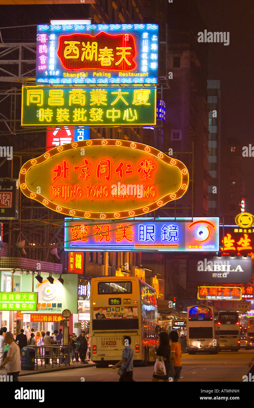 HONG KONG CHINA People and buses on Nathan Road at night in Kowloon, neon lights Stock Photo