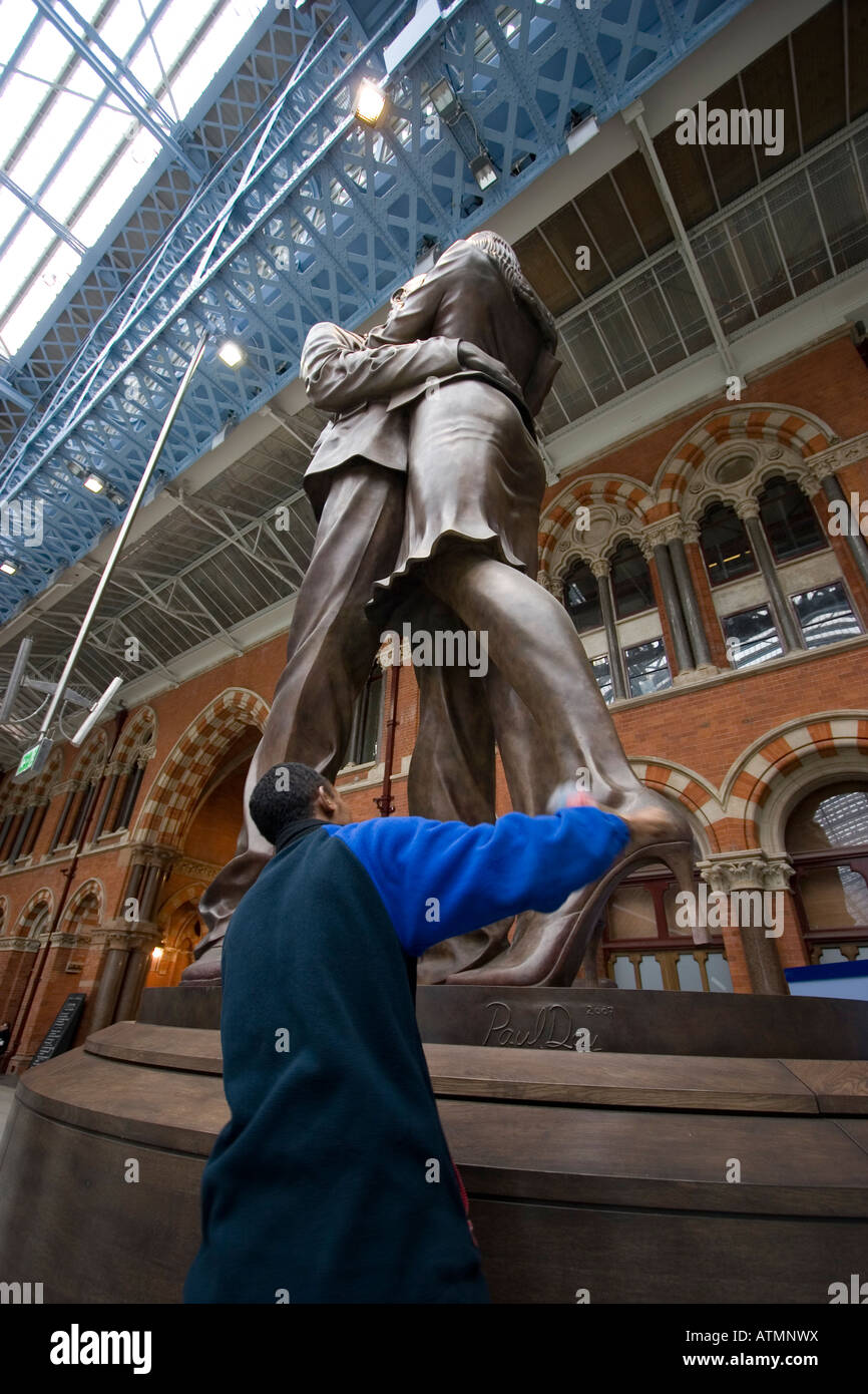 Cleaner dusting 'The meeting place' commonly as 'The Lovers statue' a ...