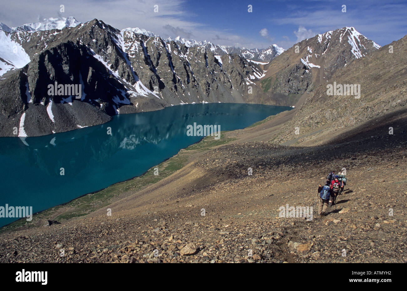 hikers at Ala Kol Ala Kul Pass 3860 m with Ala Kol Ala Kul Lake Terskey Alatau Mountains Tian Shan Kyrgyzstan Stock Photo